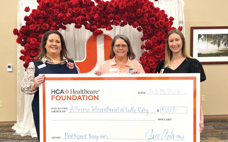 Ginny McCall (left) and Lindsey Covington (right) present a $10,000 check from HCA Florida Lake City Hospital to Sandy Thompson (center) for Altrusa International of Lake City in support of its backpack program, which provides food to local students in need. (COURTESY)