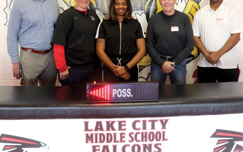 Lake City Middle School officials Dennis Dotson, Brianna Collier and basketball coach Shaniqua Henry, stand with Carl Allison and Wayne Jernigan showing off a new scorer’s table for the school which arrived Tuesday morning. (TONY BRITT/Lake City Reporter)