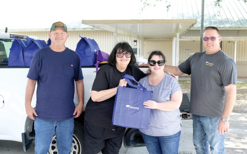 Pat Mundorff (from left) helped out Alice Martin alongside Candi Kish and Todd Martin during the Law family fundraiser. (TONY BRITT/Lake City Reporter)