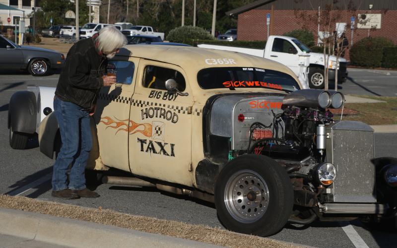 Bob Hubbard checks out the interior of the Hotrod Taxi Monday afternoon as Sick Week participants and observers flocked to Lake City for a pit stop. (MORGAN MCMULLEN/Lake City Reporter)
