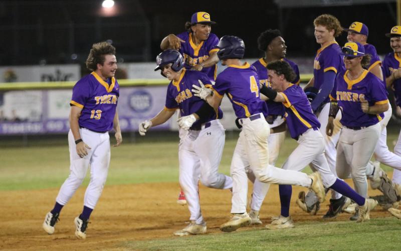 Columbia's baseball players chase after right fielder Case Bennett to celebrate following his walk-off single against St. Augustine on Wednesday. (JORDAN KROEGER/Lake City Reporter)