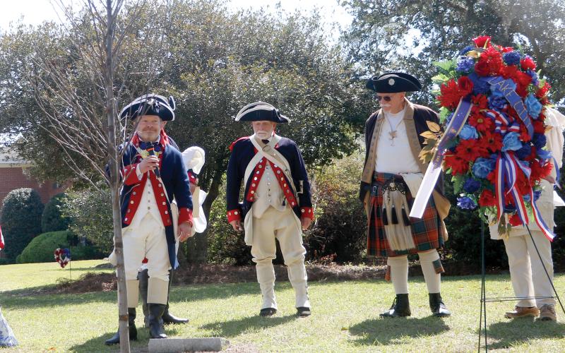 Chris Washler, the president of the Florida State Society of the Sons of the American Revolution, stands with other SAR members behind the liberty tree that was dedicated Saturday at Heritage Park and Gardens in Live Oak. (JAMIE WACHTER/Lake City Reporter)