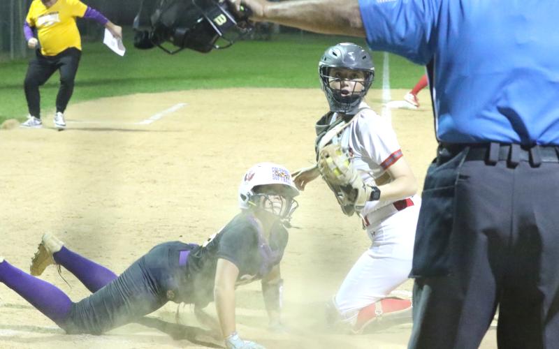 Columbia center fielder Luisa Taylor (left) and Santa Fe catcher Ainslea Kelsoe react to a safe call from the umpire during the Tigers' 13-2 loss Tuesday. (MORGAN MCMULLEN/Lake City Reporter)