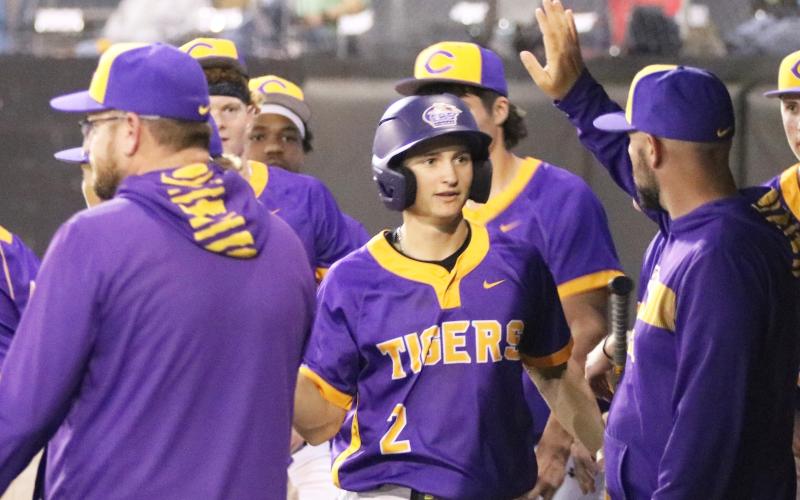 Columbia assistant coach Blake King high fives second baseman Madden Mann in the dugout after Mann scored the go-ahead run against Forest on Wednesday. (JORDAN KROEGER/Lake City Reporter)