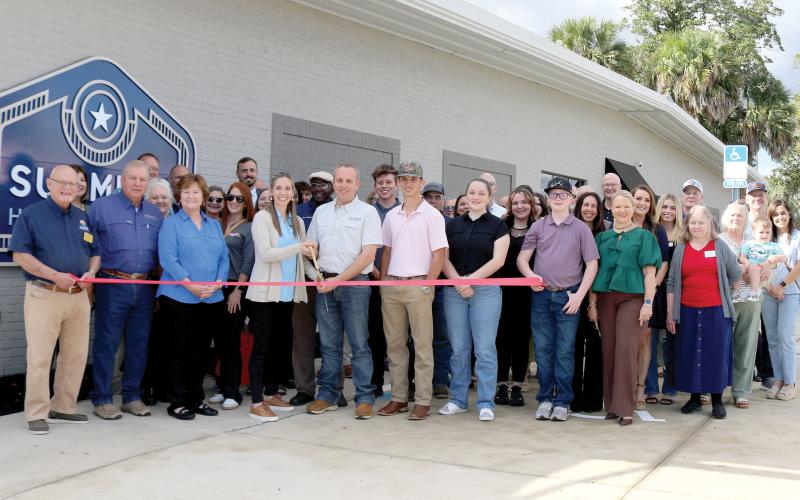 Chris Summers cut the ribbon Thursday during the grand opening celebration for Summers Home Furniture. They were joined by family, friends, employees and members of the Lake City-Columbia County Chamber of Commerce. (TONY BRITT/Lake City Reporter)