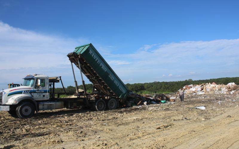 A pair of Waste Pro employees oversee the dumping of a truckload of garbage at the Columbia County Landfill. (FILE)