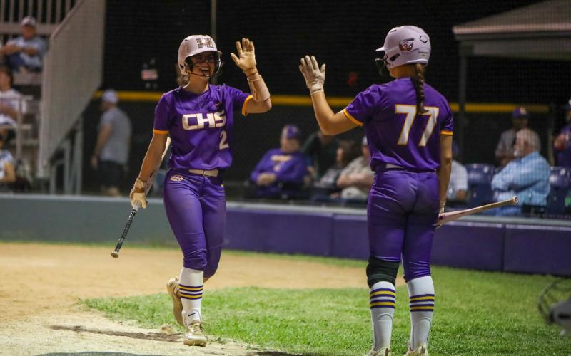 Columbia shortstop Alannah Lord (left) high fives Ryleigh Stone after scoring a run against Buchholz on Tuesday. (BRENT KUYKENDALL/Lake City Reporter)