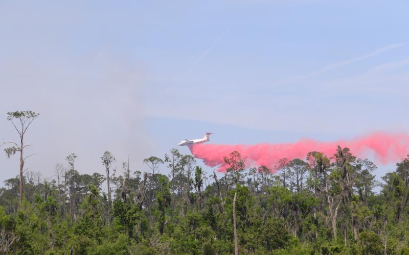 A tanker drops fire retardant on the ongoing brushfire in the Osceola National Forest near the gun range on the northeast side of Lake City. (TONY BRITT/Lake City Reporter)