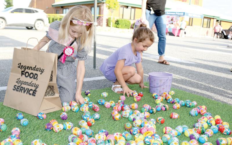 Riley Poirier (left), 8, and Kingsley Burnham, 4, look through Easter eggs at the Movement Mortgage Tent on Tuesday evening at the Texas Roadhouse Second Annual Easter Egg Hop event. (TONY BRITT/Lake City Reporter)