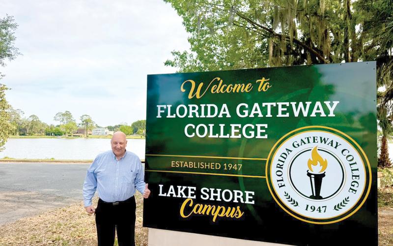 Florida Gateway College President Larry Barrett approves of the college’s new sign for its Lake Shore campus next to the former two-story women’s center building on the banks of Lake DeSoto in downtown Lake City. (COURTESY FLORIDA GATEWAY COLLEGE)