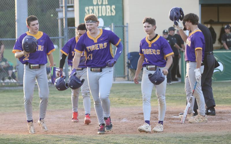 Columbia first baseman Nolan Slaymaker (17) runs back to the dugout with a smile on his face after hitting a grand slam that drove in Nate Stapleton (22), Abraham Martinez (back) and Madden Mann (2) during the first inning of the Tigers’ 6-2 win over Fleming Island in the District 3-5A championship on Thursday. (JORDAN KROEGER/Lake City Reporter)