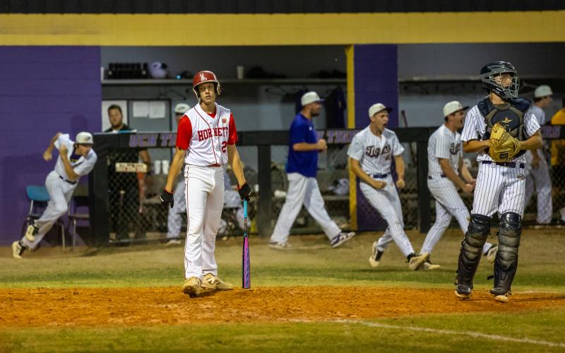 Lafayette's Kagan Hewett goes down on a called third strike to end the game as Union County celebrates in the District 6-R championship on Thursday. (JACK HOWDESHELL/Lake City Reporter)