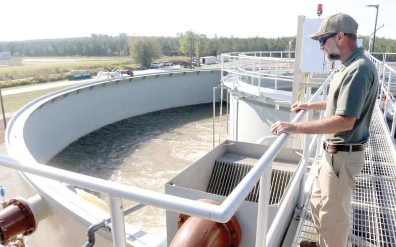 Cody Pridgeon, City of Lake City wastewater director, looks in on a tank of untreated wastewater at the North Florida Mega Industrial Park wastewater treatment plant last March shortly after it began operating. (FILE)
