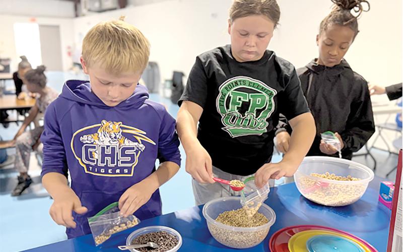 Third grade students at Niblack Elementary practice measuring by making their own trail mix through the nutrition lessons taught by UF/IFAS Extension Columbia County during PE classes at the school. (COURTESY UF/IFAS EXTENSION COLUMBIA COUNTY)