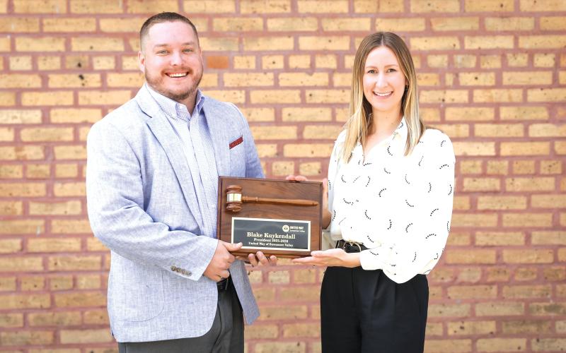 Outgoing United Way of Suwannee Valley President Blake Kuykendall (left) is awarded a ceremonial gavel by President-Elect Lindsey Covington. (COURTESY)