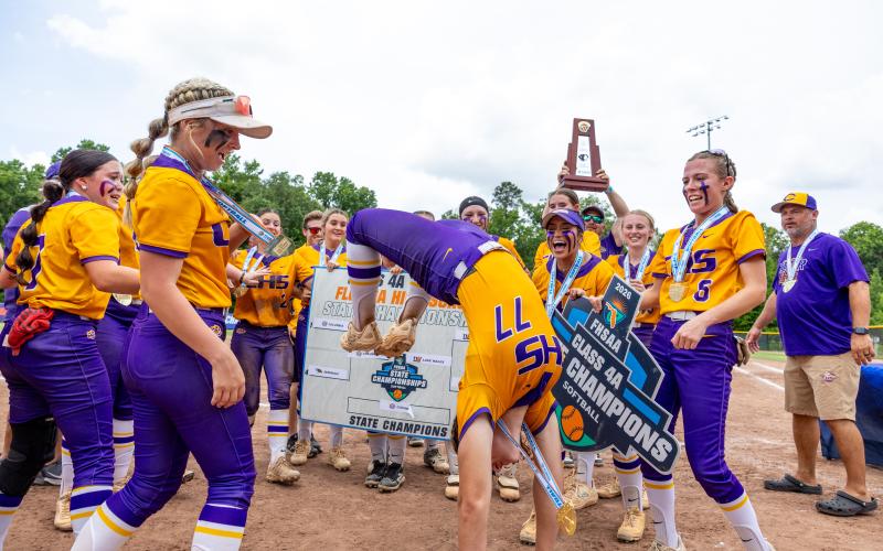 Columbia pitcher Ryleigh Stone (77) does a backflip as her teammates celebrate following their 3-2 win over Lake Wales in the Class 4A state championship on Saturday. (JACK HOWDESHELL/Lake City Reporter)