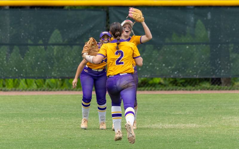 Columbia shortstop Alannah Lord (2) runs toward right fielder Marlee Hunt (right) to celebrate as Hunt is hugged by center fielder Luisa Taylor (left) after Hunt caught the final out of Saturday's 3-2 win over Lake Wales in the Class 4A state championship. (JACK HOWDESHELL/Lake City Reporter)