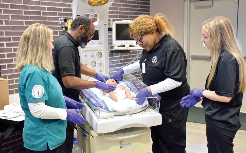 Nursing students at Florida Gateway College check on a doll who is on a radiant warmer donated to the school by the Lake Shore Hospital Authority. (COURTESY FLORIDA GATEWAY COLLEGE)