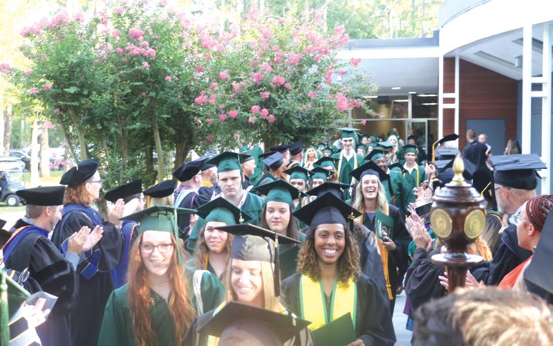 Florida Gateway College graduates file out of the Howard Center through columns of FGC  faculty and staff following a prior year’s graduation ceremony. (FILE)