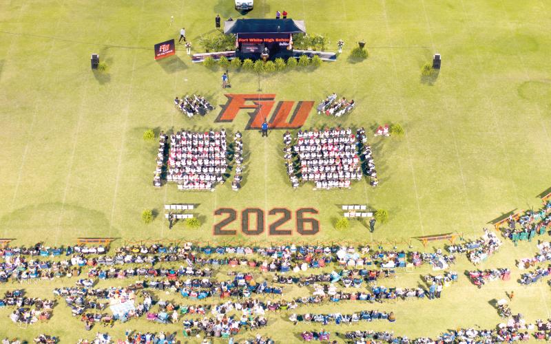 Family and friends surround the graduates on the field at Arrowhead Stadium on Friday night as Fort White High held its commencement ceremony for the Class of 2026. The ceremony was interrupted for about 45 minutes due to lightning in the area. (RAY CARPENTER/Lake City Reporter)