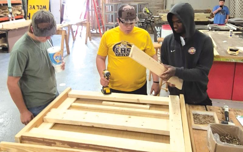 Mason Carrol (from left), Ashton Ambrose and Jordaeton Youmans work on making one of the beds for the local chapter of Sleep in Heavenly Peace. (COURTESY)