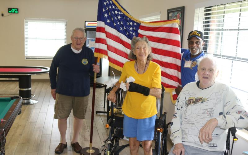 U.S. Army veterans John “Dutch” Shultz (foreground from left), Dawn Huston and Terry Holliday pose for a Flag Day photograph as  Kenneth Burkes, an American Legion member, holds the flag. (TONY BRITT/Lake City Reporter)