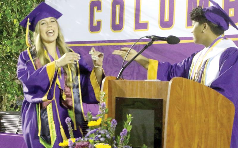 CHS Class of 2026 valedictorian Nathan Chiong (right) pays off his four-year-long $5 bet with Kadence Bates-Rogers during Friday’s commencement ceremony. (MORGAN MCMULLEN/Lake City Reporter)