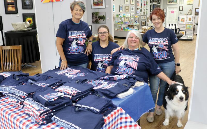 Lisa Amparo (from left), Mikael Byrd, Kathy Olson, Shelia Carr and Cooper take pose for a photo with the 250th anniversary celebration T-shirts while at the Gateway Art Gallery on Tuesday afternoon. The T-shirts are for sale at $10 each. (TONY BRITT/Lake City Reporter)