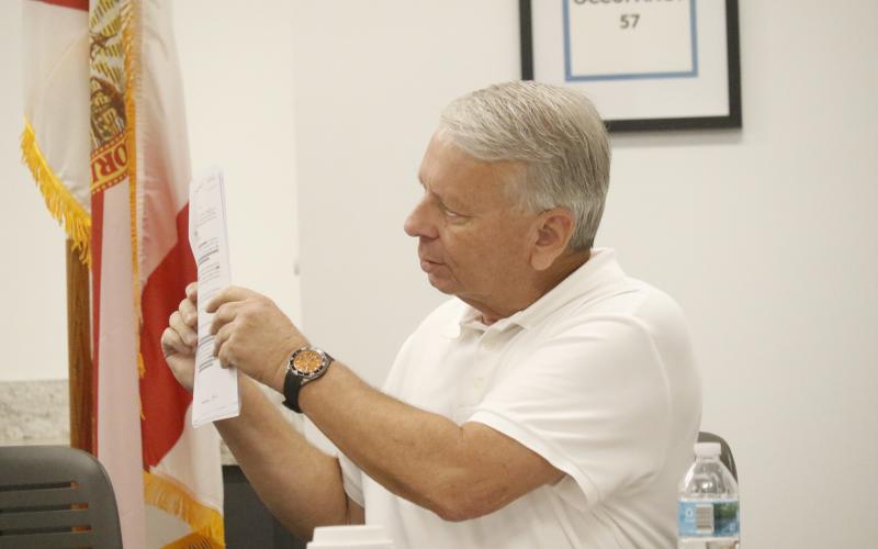North Florida Water Utilities Authority Attorney Grady Williams holds up one of the agreements that established the NFWUA during Monday’s meeting. Williams and Executive Director Shannon Roberts asked the board for direction as far as to the timeline for transferring assets from Columbia and Suwannee counties to the Authority. (JAMIE WACHTER/Lake City Reporter)