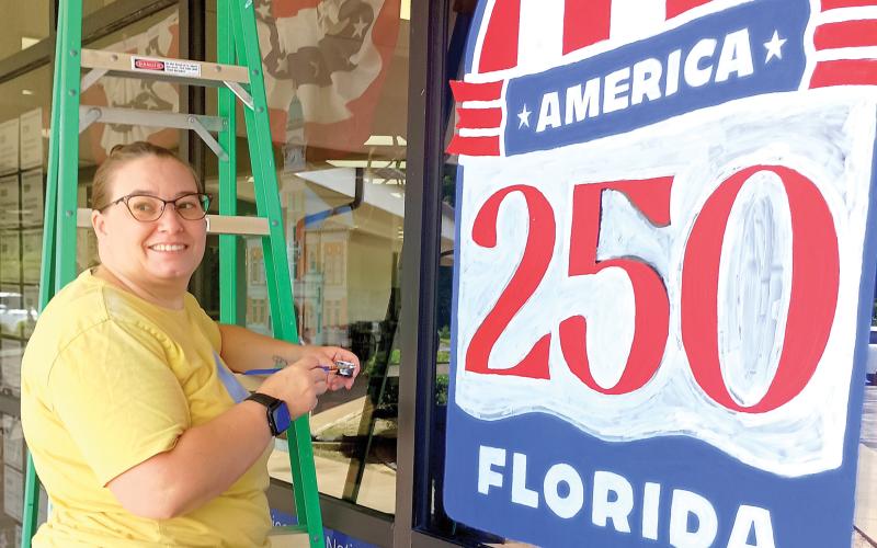 Artist Maggie Wilburn finishes up her America 250 art work on the Suwannee River Regional Library’s Live Oak branch ahead of the July 4 holiday. (ROB WOLFE/Lake City Reporter)
