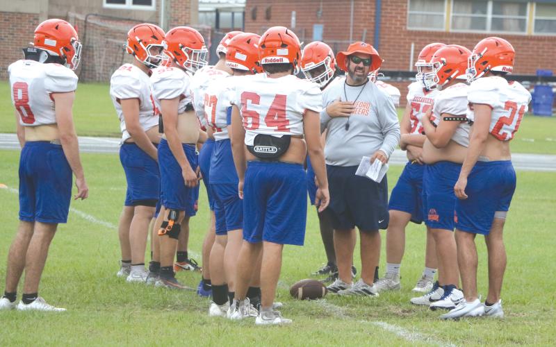 Branford coach Will Dettor works with his defensive line during Thursday’s practice. (MORGAN MCMULLEN/Lake City Reporter)