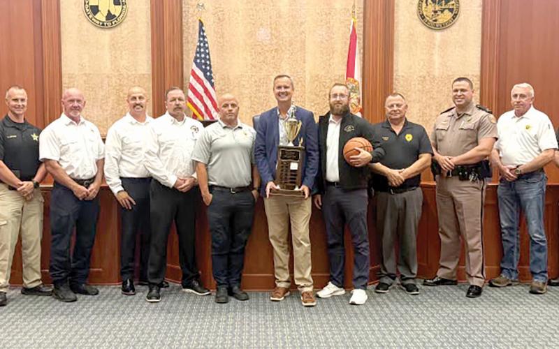 Columbia County Clerk of Court Jay Swisher holds the Boots and Badges championship trophy ahead of this year’s tournament. The Legal Eagles, representing attorneys at the courthouse, are the defending champions. (COURTESY)