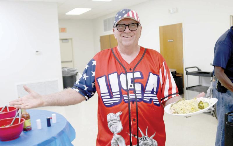 Layne Schultetus, clad in an American jersey, was all smiles with a plate full of the chicken perlau dinner ahead of Thursday’s Columbia County GOP candidate rally at the Westside Community Center. (TONY BRITT/Lake City Reporter)