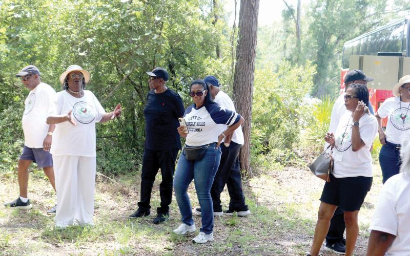 Leila Williams (far left) talks about the Union Burial Ground Cemetery where Hankerson family members were buried. Williams helped organize the tour for Hankerson family descendants through Columbia, Hamilton and Suwannee counties last Saturday. (TONY BRITT/Lake City Reporter)