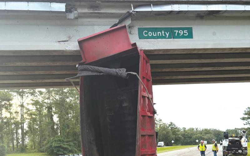 A dump truck’s bed sits in the eastbound lanes of Interstate 10 after hitting the County Road 795 overpass on Monday. (COURTESY FHP)