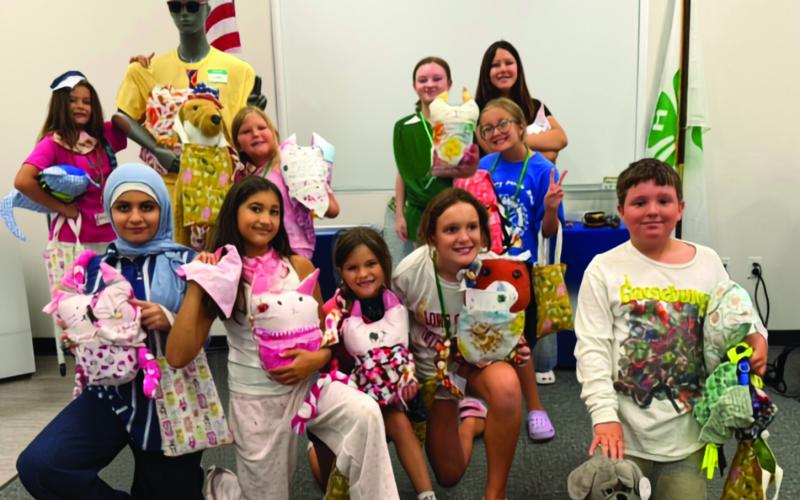 Campers pose with all of their completed projects next to the sewing mascot mannequin ‘Chad.’ (COURTESY UF/IFAS EXTENSION COLUMBIA COUNTY)