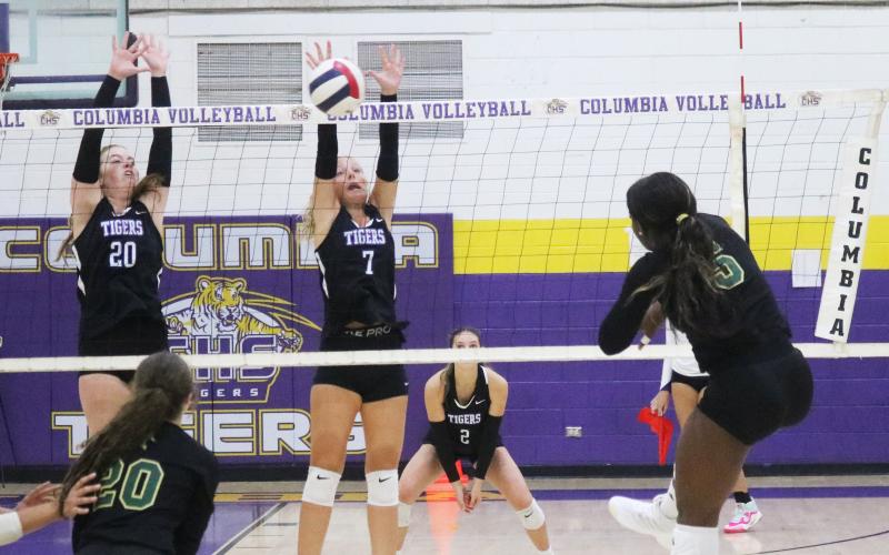 Lincoln outside hitter Jaci Dickens fires a shot towards Columbia hitter Langsley Smith (20) and Addison Jones (7) on Thursday. (JORDAN KROEGER/Lake City Reporter)