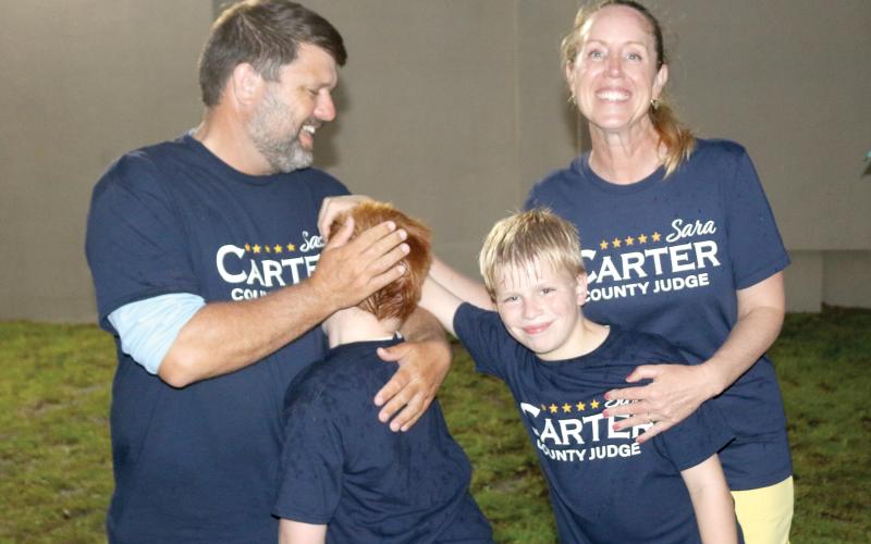 Sara Carter celebrates with her husband, Travis, and sons, Jack (left) and George after winning re-election as Columbia County judge on Tuesday night. (TONY BRITT/Lake City Reporter)