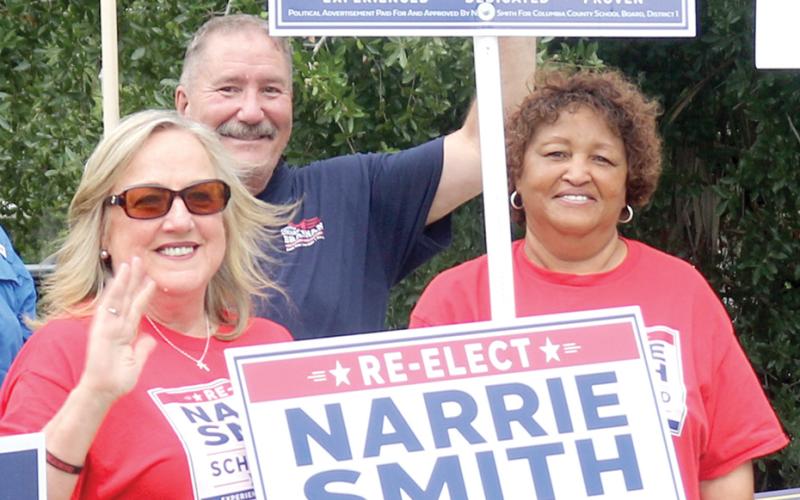 Narrie Smith (right) holds a campaign sign alongside a supporter Tuesday outside the Supervisor of Elections office. (TONY BRITT/Lake City Reporter)