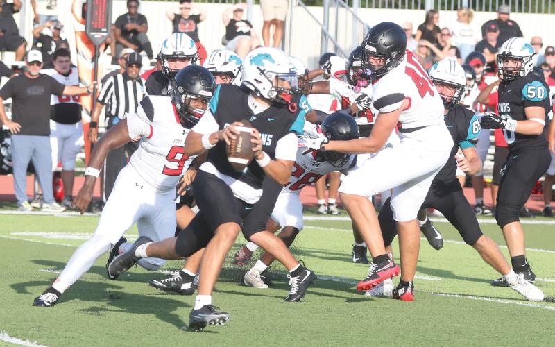 Fort White defensive linemen Josiah Harmon (9) and Cillian Sheehan (40) chase after Providence quarterback Andrew Posey during last Friday’s Kickoff Classic. (MORGAN MCMULLEN/Lake City Reporter)