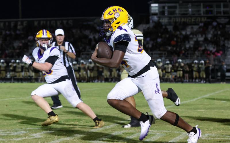 Columbia defensive end Jae’Quan Wilson races toward the end zone after scooping up an Oakleaf fumble Friday night while linebacker Bryson Grinstead looks on. Wilson scored on the play. (GARY LLOYD MCCULLOUGH/Special to the Reporter)