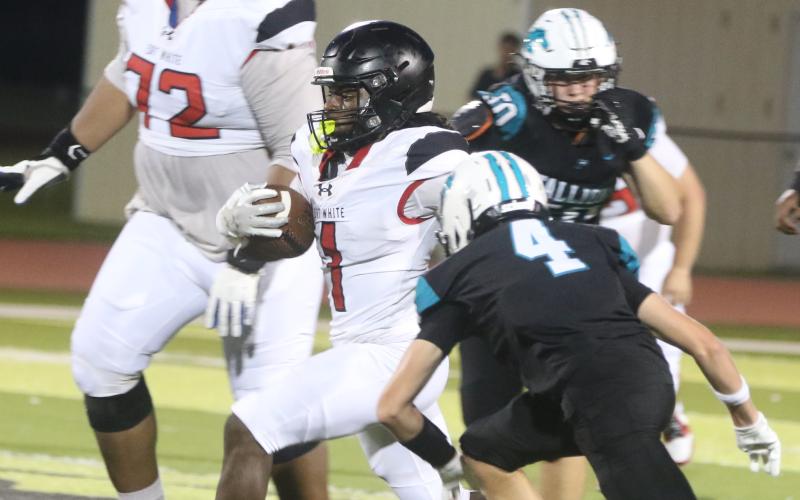 Fort White running back John'l Lawson runs by Providence defensive back Malachi Baughman on Friday night. (MORGAN MCMULLEN/Lake City Reporter)