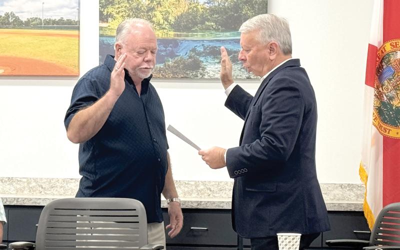 North Florida Utilities Authority board member Jock Phelps (left) is sworn in ahead of Monday’s meeting by NFWUA Attorney Grady Williams. Monday was Phelps’ first meeting as a member of the utility board. (JAMIE WACHTER/Lake City Reporter)