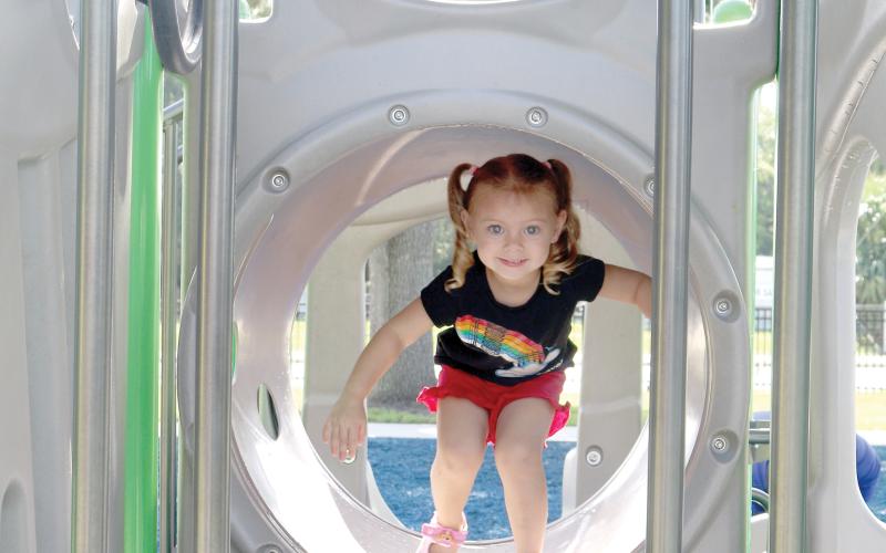 Ellie Davis makes her way through a tunnel on a piece of equipment at Sallie Mae Jerry Park on Friday. (TONY BRITT/Lake City Reporter)