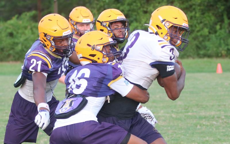 Columbia receiver Zion Walker fights to break away from a tackle from defensive back Mekah Combs-Turner (16) as defensive backs Jermone Carter (21) and Chris Austin (back) give chase during Wednesday’s practice. (JORDAN KROEGER/Lake City Reporter)