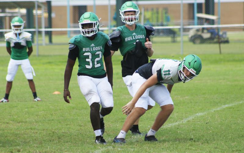 Suwannee quarterback Haigen Johnson (11) rushes a pass after being pressured by linebackers Travis Fead (32) and Kyler Watson during Monday’s practice. (JAMIE WACHTER/Lake City Reporter)