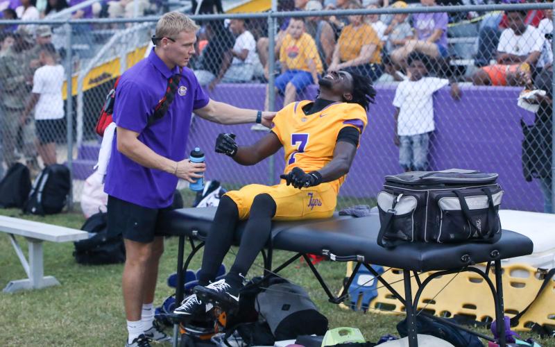 Columbia receiver Kyren Caldwell is attended to by the team trainer after spraining his ankle during last week’s win over Lakewood. (BRENT KUYKENDALL/Lake City Reporter)
