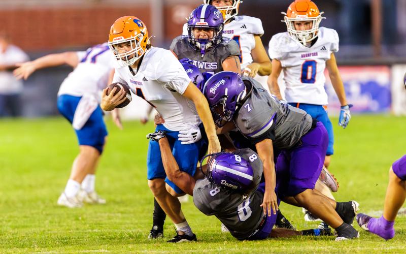 Branford quarterback Trent Land (4) gets tackled by a swarm of Bell defenders during Friday’s 27-14 loss. (JACK HOWDESHELL/Lake City Reporter)