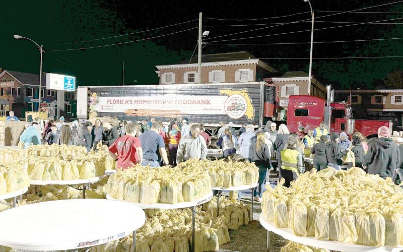 Volunteers help set up for a previous Farm Share food distribution hosted by the Lake City Police Department. A food giveaway is scheduled for Saturday, beginning at 8 a.m. in downtown Lake City. (FILE)