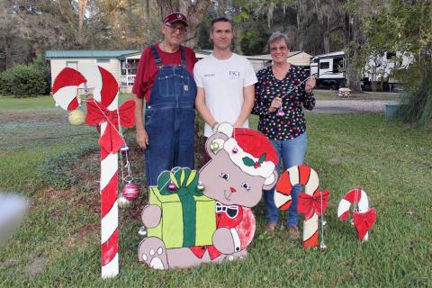 Callahan’s Fred Heinrich, son William Heinrich, Jr. and fiancée Cheryl Hodge stand near one of the themed creations that are on display in their yard on Old Dixie Highway in Callahan.